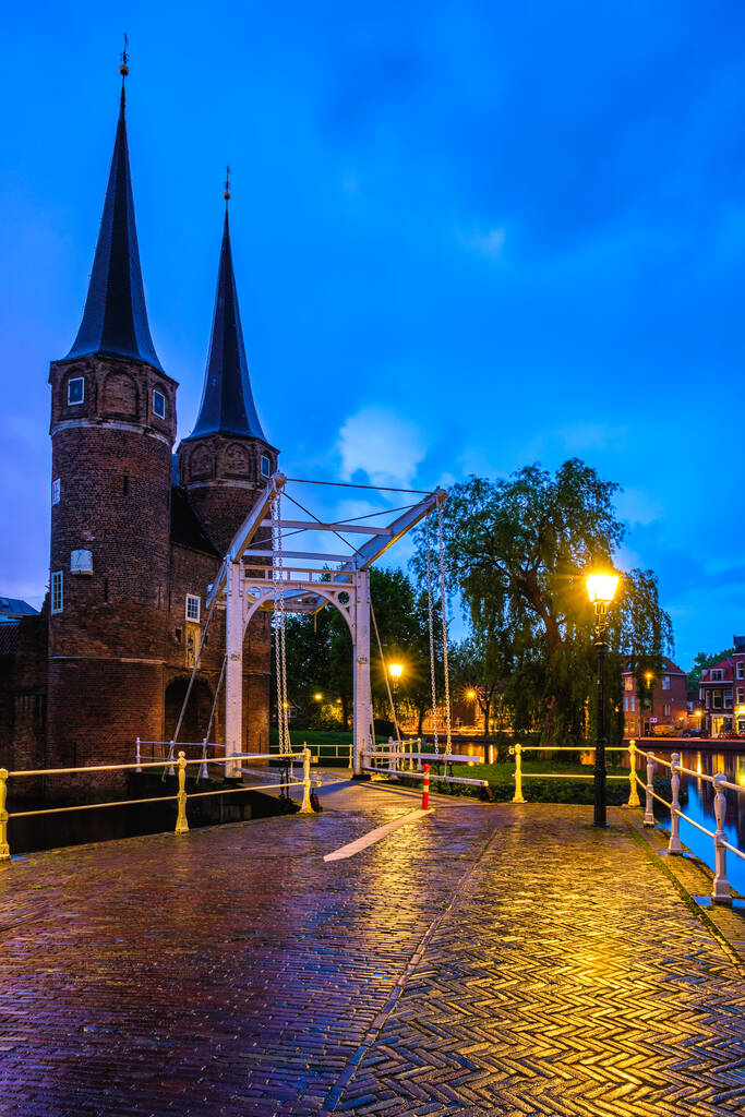Oostpoort in Delft verlicht tijdens het blauwe uur