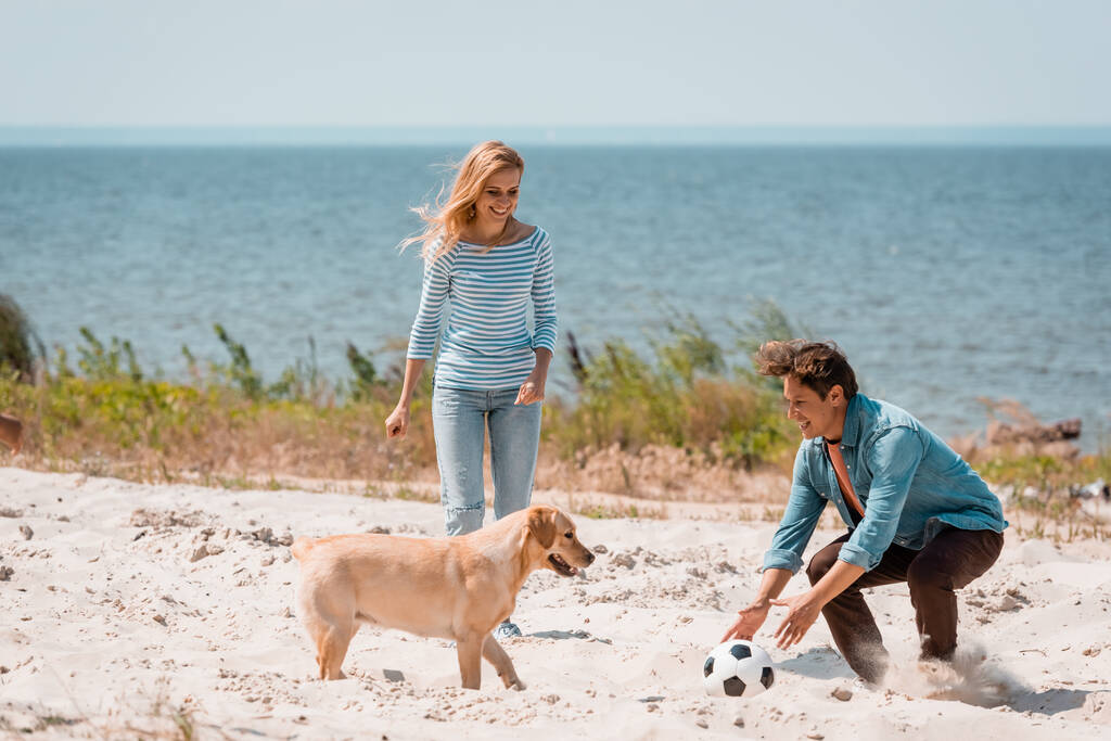 Stel speelt met een hond op het strand