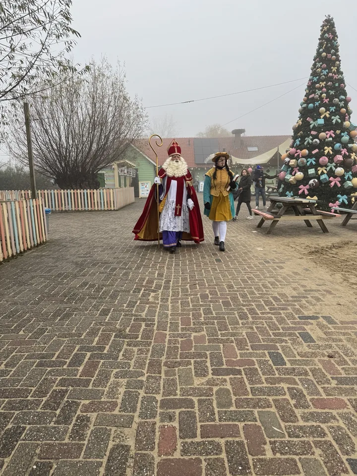 Sinterklaasbezoek met een feestelijke kerstboom op de achtergrond