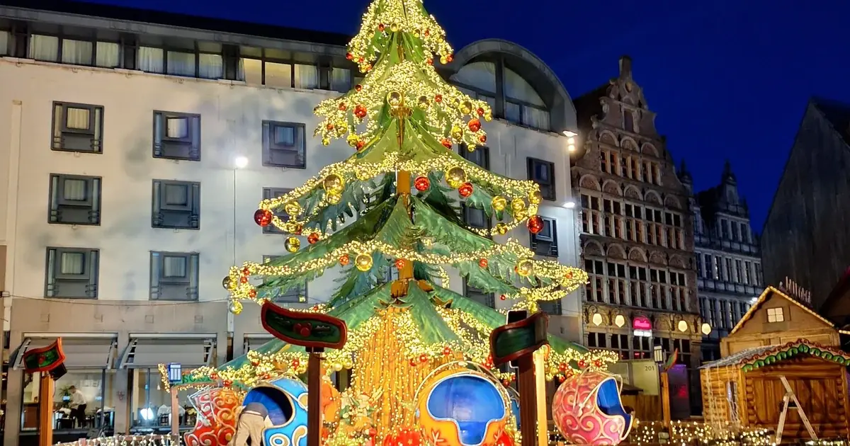Sfeervolle kerstmarkt met lichtjes en houten chalets in een Vlaamse stad