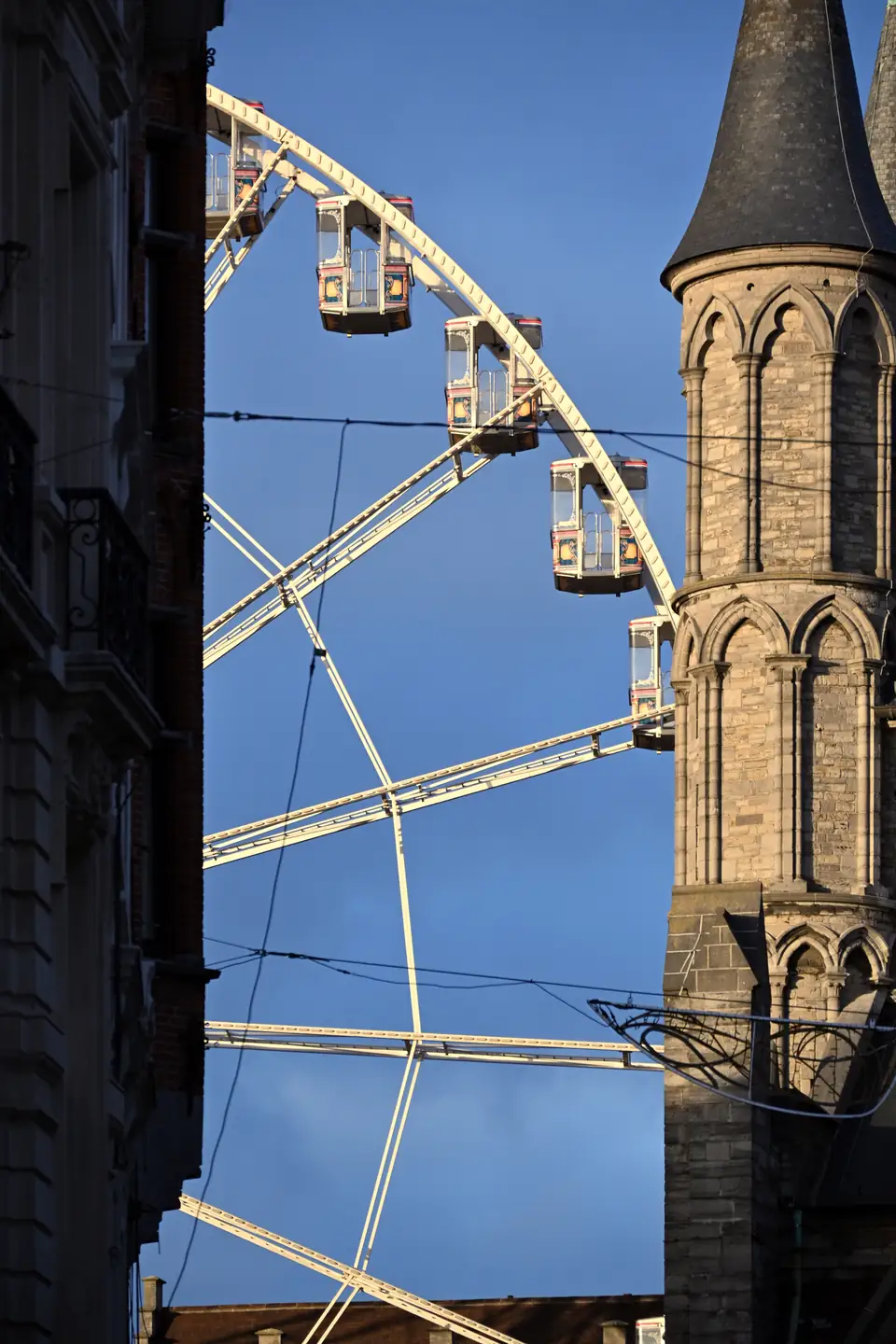 Reuzenrad met de Sint-Niklaaskerk in Gent bij zonsondergang tijdens de vorige wintereditie