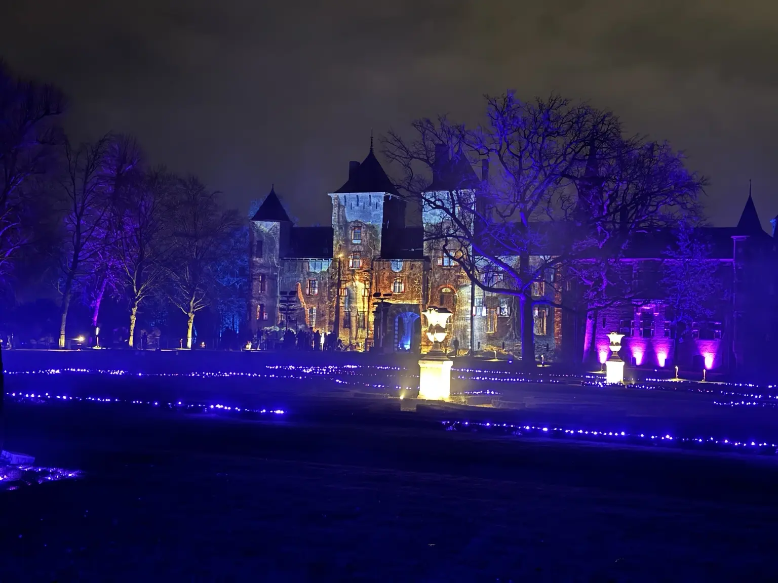 Breed uitzicht op het verlichte Kasteel de Haar en de kasteeltuin
